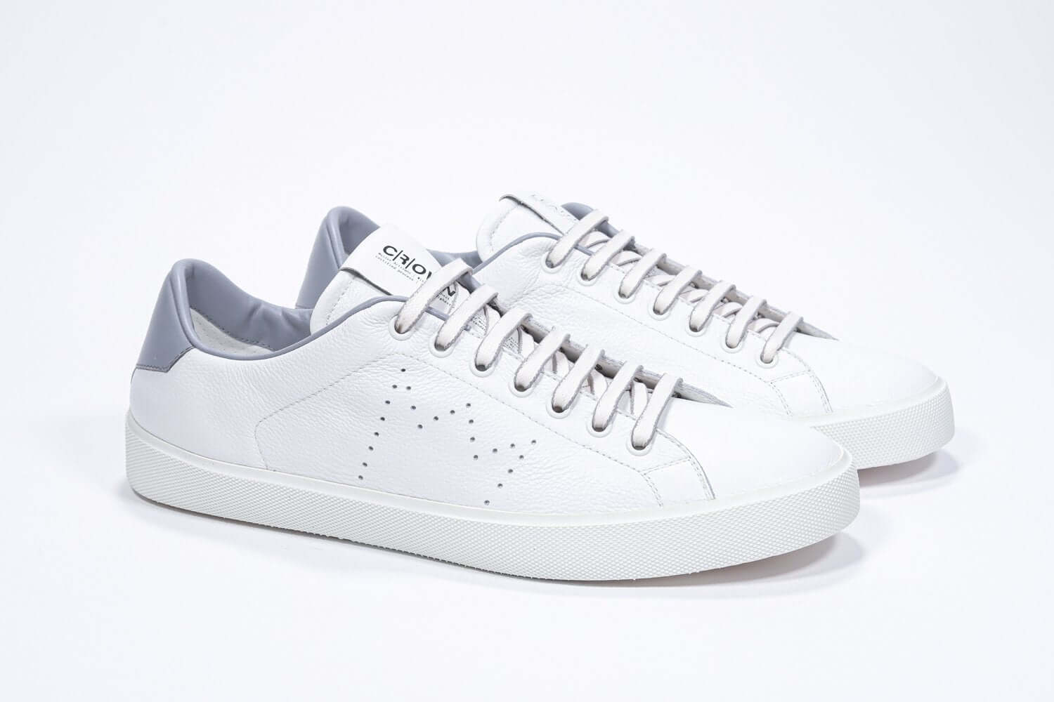 Tre quarti di BASSE  sneaker  bianco con dettagli grigio chiaro e logo della corona traforato sulla tomaia. Tomaia in pelle e suola in gomma bianca.