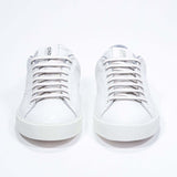 Vista frontale di BASSE  sneaker  bianco con dettagli grigio chiaro e logo della corona traforato sulla tomaia. Tomaia in pelle e suola in gomma bianca.