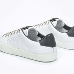 Three quarter back view of low top white sneaker with military green detailing and perforated crown logo on upper. Full leather upper and white rubber sole.