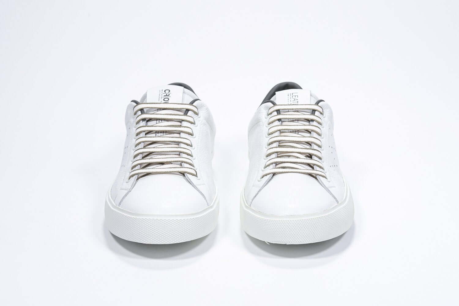 Front view of low top white sneaker with military green detailing and perforated crown logo on upper. Full leather upper and white rubber sole.