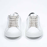 Front view of low top white sneaker with military green detailing and perforated crown logo on upper. Full leather upper and white rubber sole.