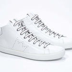 Three quarter view of mid top white sneaker with full leather upper with perforated crown logo and white sole.