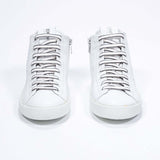 Front view of mid top white sneaker with full leather upper with perforated crown logo and white sole.