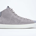 Profilo laterale del mid top grigio chiaro sneaker con tomaia interamente in pelle scamosciata con logo della corona traforato, zip interna e suola bianca.