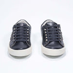 Vue de face de la chaussure noire sneaker. Tige en cuir avec clous et semelle en caoutchouc vintage.