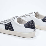 Back view of low top white and navy sneaker. Full grain leather upper with gunmetal studs and vintage rubber sole.