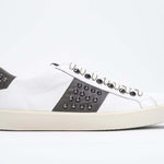 Side profile of low top white and khaki sneaker. Full grain leather upper with gunmetal studs and vintage rubber sole.