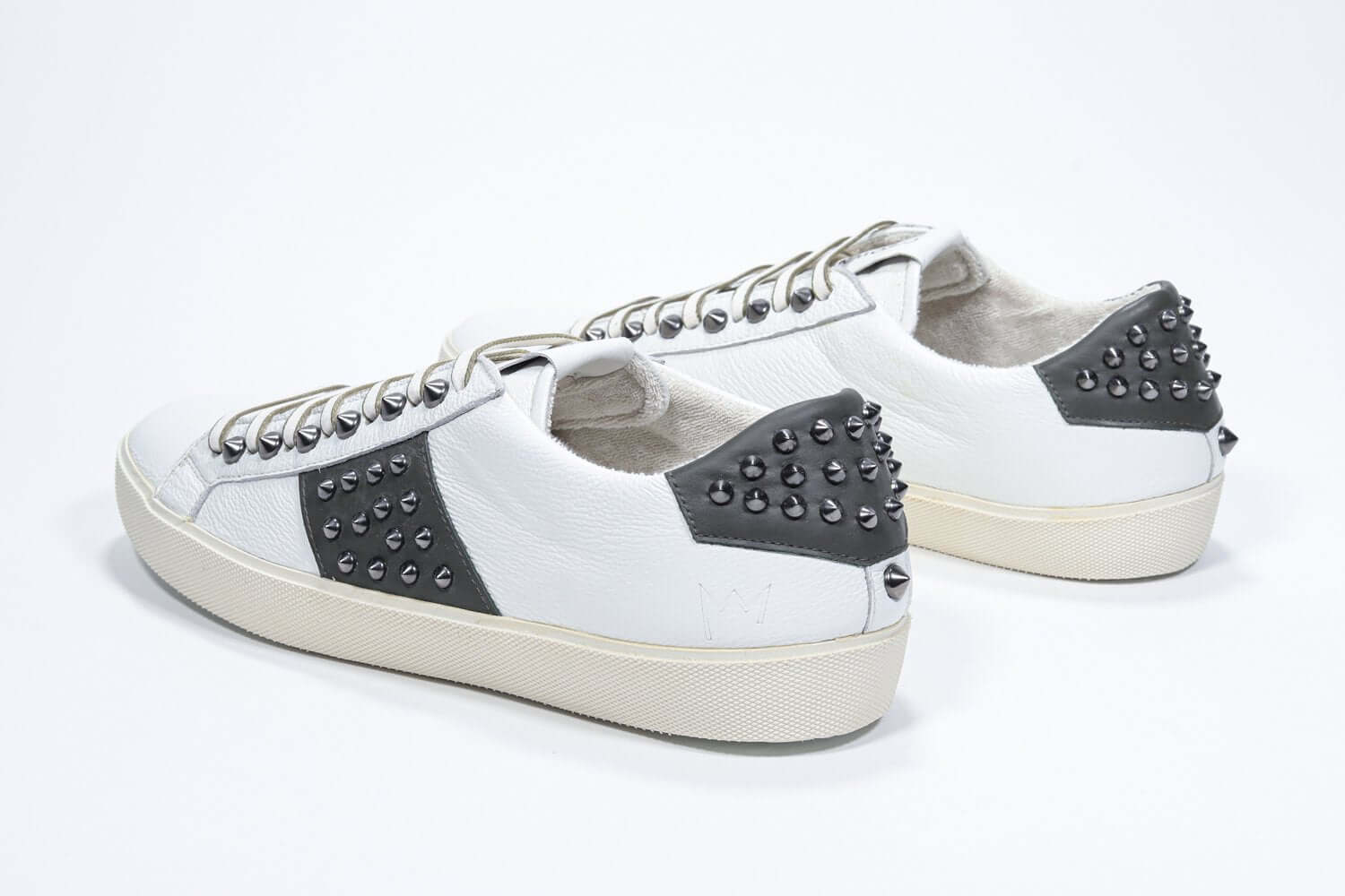 Back view of low top white and khaki sneaker. Full grain leather upper with gunmetal studs and vintage rubber sole.