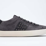 Side profile of low top grey sneaker. Suede upper with gunmetal studs and vintage rubber sole.