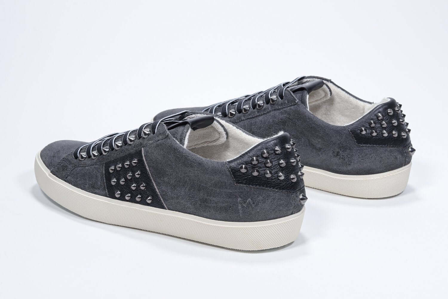 Back view of low top grey sneaker. Suede upper with gunmetal studs and vintage rubber sole.