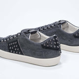 Back view of low top grey sneaker. Suede upper with gunmetal studs and vintage rubber sole.