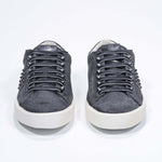 Front view of low top grey sneaker. Suede upper with gunmetal studs and vintage rubber sole.