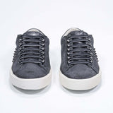 Front view of low top grey sneaker. Suede upper with gunmetal studs and vintage rubber sole.