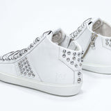 Vista posteriore di tre quarti del modello mid top bianco sneaker. Tomaia in pelle con borchie, zip interna e suola in gomma bianca.