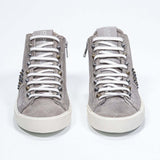 Front view of mid top beige sneaker. Full suede upper with studs, an internal zip and vintage rubber sole.