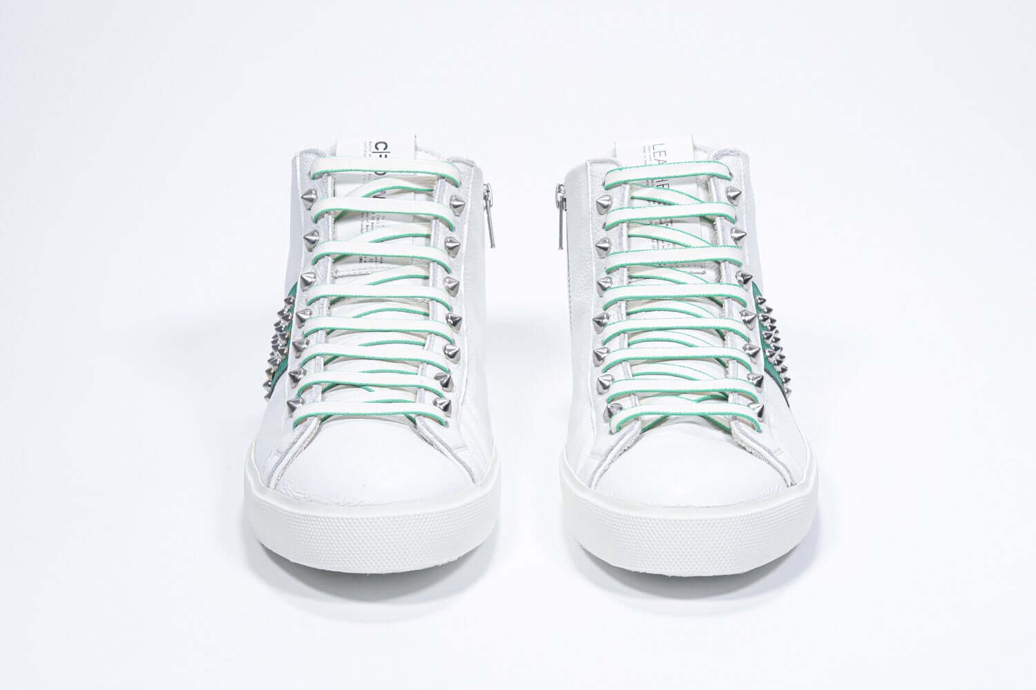 Vorderansicht des weißen und grünen Mid-Top sneaker. Obermaterial aus Vollleder mit Nieten, einem internen Reißverschluss und weißer Gummisohle.