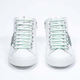 Vorderansicht des weißen und grünen Mid-Top sneaker. Obermaterial aus Vollleder mit Nieten, einem internen Reißverschluss und weißer Gummisohle.