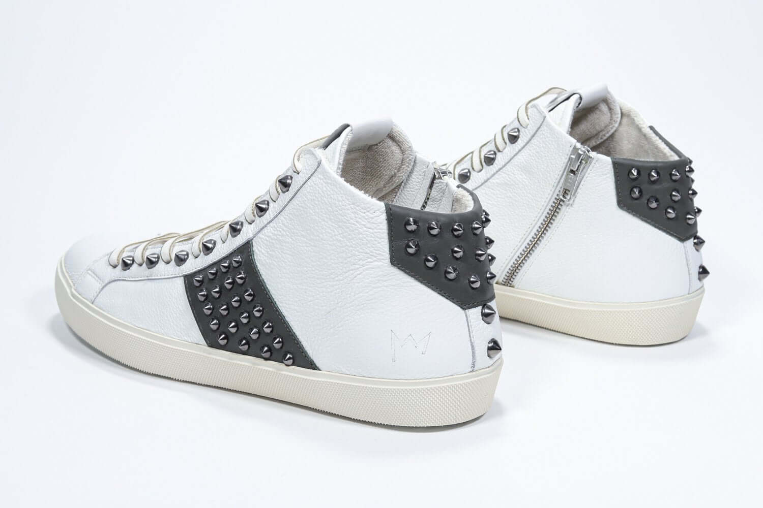 Dreiviertelansicht der Rückseite von Mid Top weiß und militärisch grün sneaker. Obermaterial aus Vollleder mit Nieten, einem internen Reißverschluss und einer Vintage-Gummisohle.