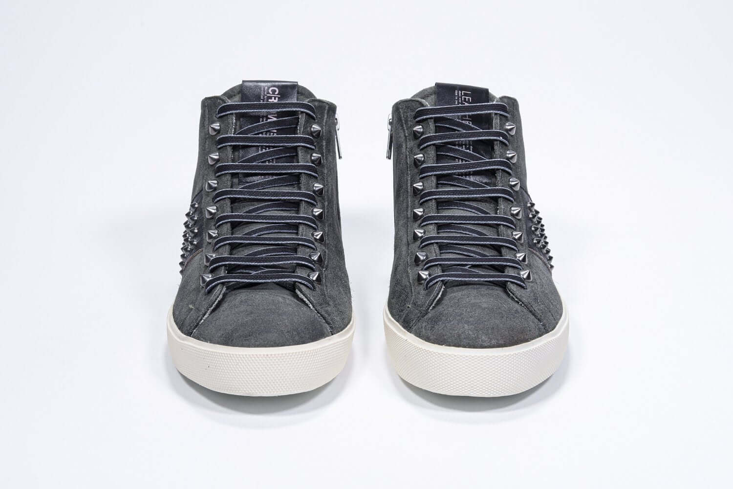 Vorderansicht des Mid Top Military Green sneaker. Obermaterial aus Wildleder und Leder mit Nieten, einem internen Reißverschluss und einer Vintage-Gummisohle.
