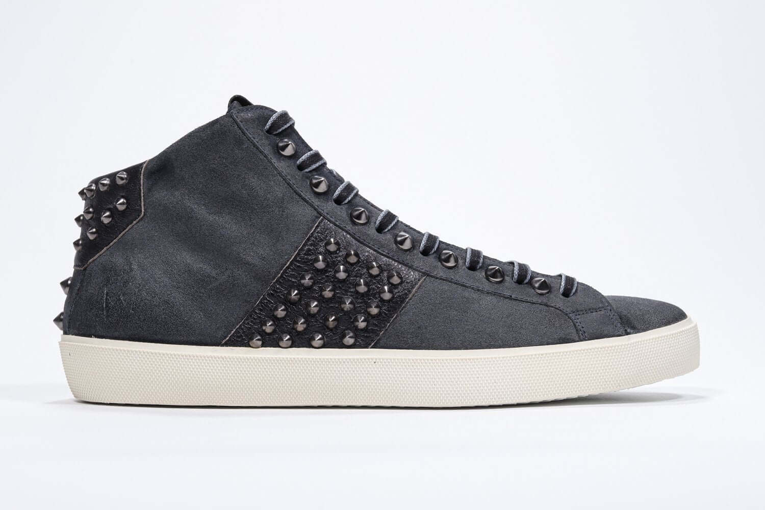Seitenprofil von mid top navy sneaker. Obermaterial aus Wildleder und Leder mit Nieten, einem internen Reißverschluss und einer Vintage-Gummisohle.