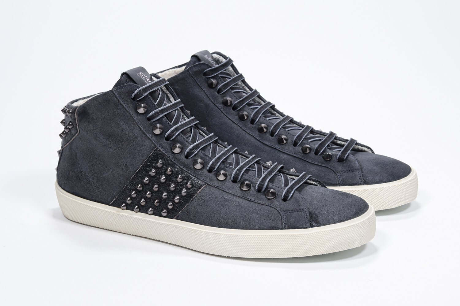 Dreiviertelansicht der Vorderseite des navyfarbenen Mid Top sneaker. Obermaterial aus Wildleder und Leder mit Nieten, einem internen Reißverschluss und einer Vintage-Gummisohle.