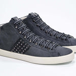 Dreiviertelansicht der Vorderseite des navyfarbenen Mid Top sneaker. Obermaterial aus Wildleder und Leder mit Nieten, einem internen Reißverschluss und einer Vintage-Gummisohle.