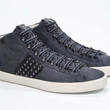 Dreiviertelansicht der Vorderseite des navyfarbenen Mid Top sneaker. Obermaterial aus Wildleder und Leder mit Nieten, einem internen Reißverschluss und einer Vintage-Gummisohle.