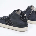 Dreiviertelansicht der Rückseite des navyfarbenen Mid Top sneaker. Obermaterial aus Wildleder und Leder mit Nieten, einem internen Reißverschluss und einer Vintage-Gummisohle.