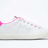 Profil latéral de la chaussure blanche sneaker avec des détails rose néon et le logo perforé de la couronne sur la tige. Tige en cuir et semelle en caoutchouc blanc.