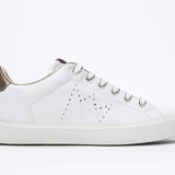 Vue de profil de la chaussure blanche sneaker avec des détails dorés et le logo perforé de la couronne sur la tige. Tige en cuir et semelle en caoutchouc blanc.