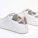 Dreiviertelansicht der Rückseite des weißen Low-Top-Schuhs sneaker mit roségoldenen Metallic-Details und perforiertem Kronenlogo auf dem Obermaterial. Obermaterial aus Vollleder und weiße Gummisohle.