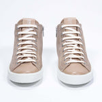 Vue de face du modèle cuoio sneaker à tige en daim avec logo perforé, fermeture éclair interne et semelle blanche.