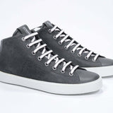 Three quarter front view of mid top military green sneaker with full suede upper with perforated crown logo, internal zip and white sole.