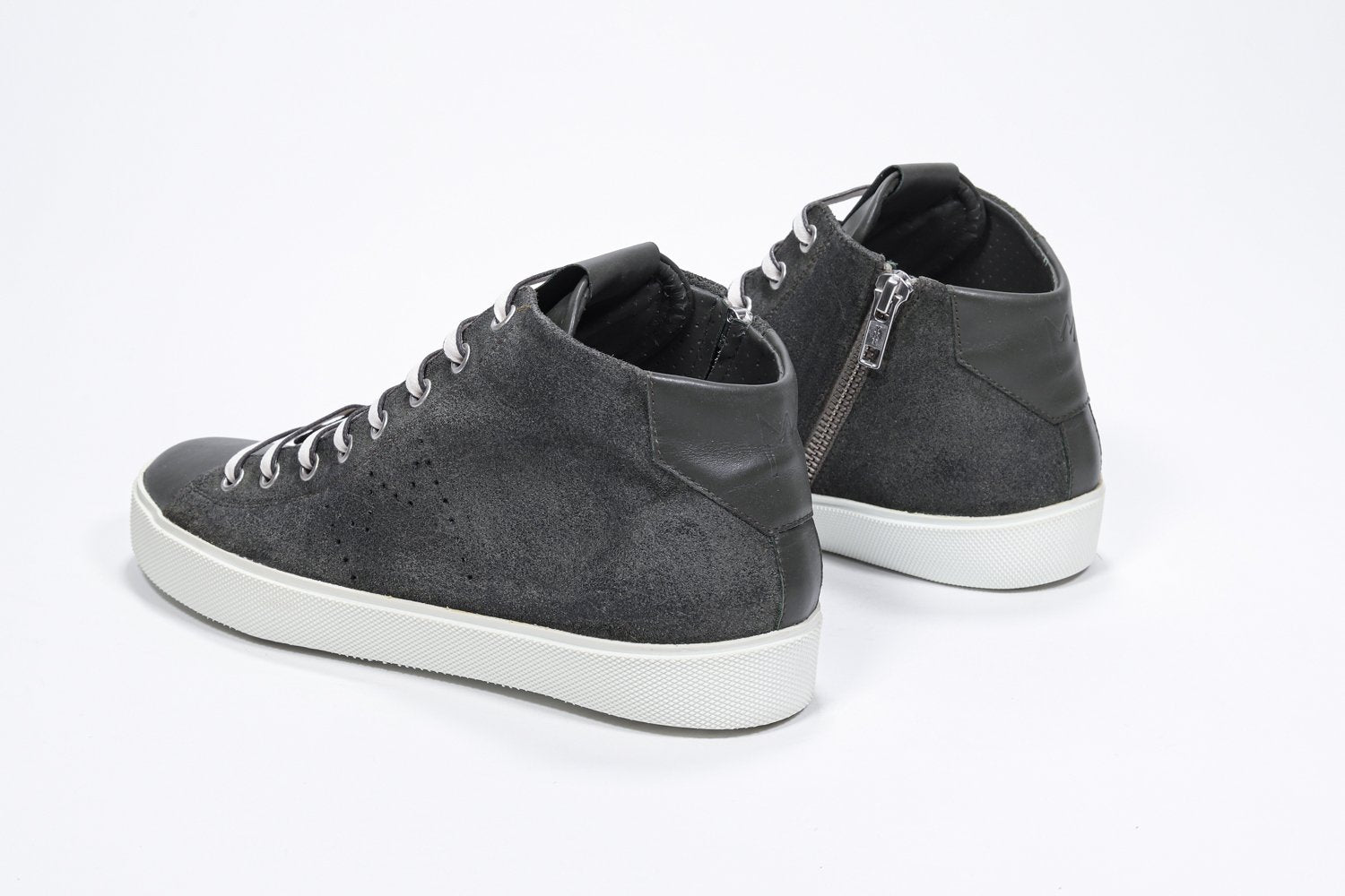 Three quarter back view of mid top military green sneaker with full suede upper with perforated crown logo, internal zip and white sole.