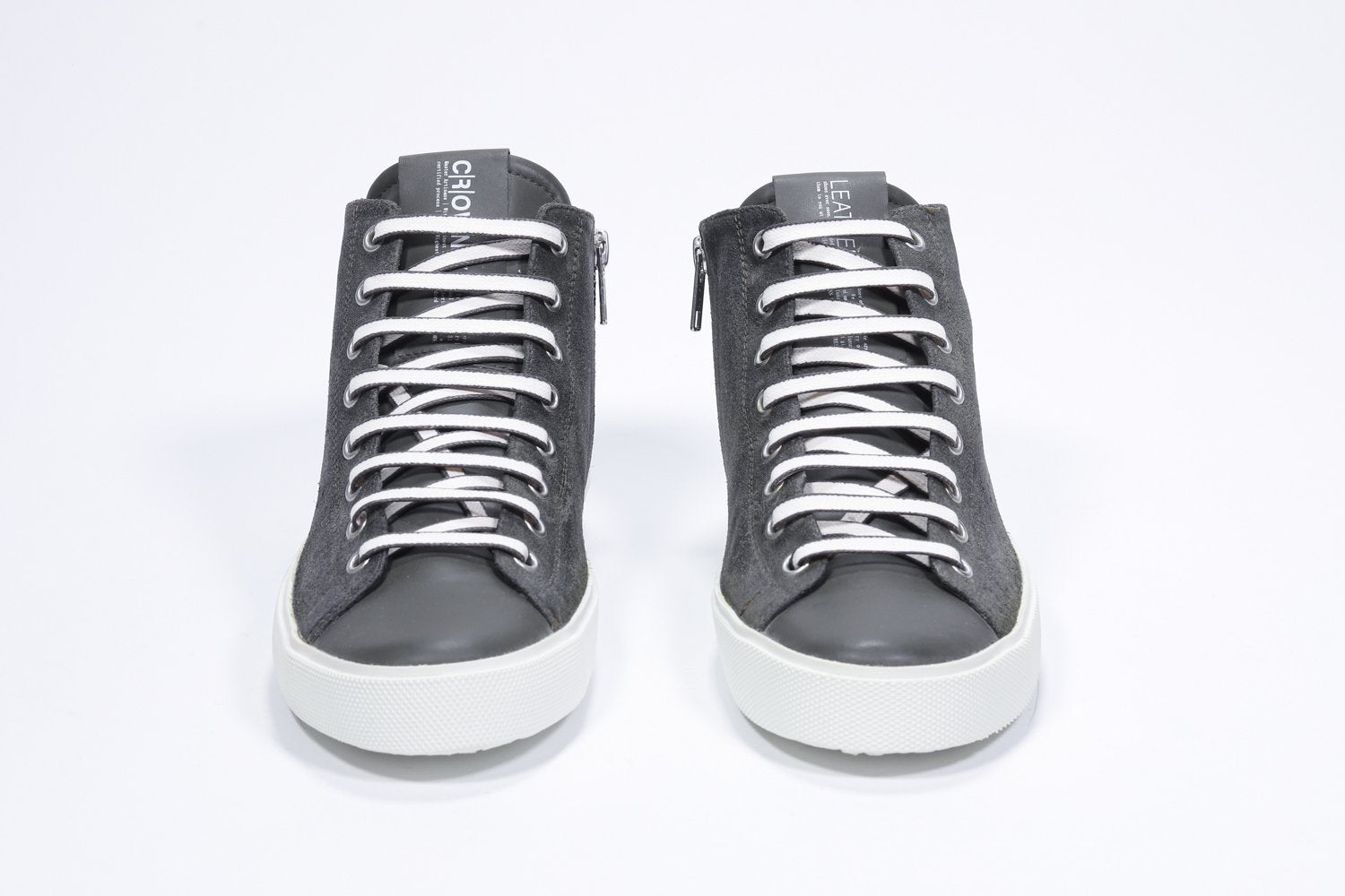 Front profile of mid top military green sneaker with full suede upper with perforated crown logo, internal zip and white sole.