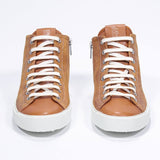 Devant de la chaussure rust sneaker avec tige en daim avec logo perforé, fermeture éclair interne et semelle blanche.