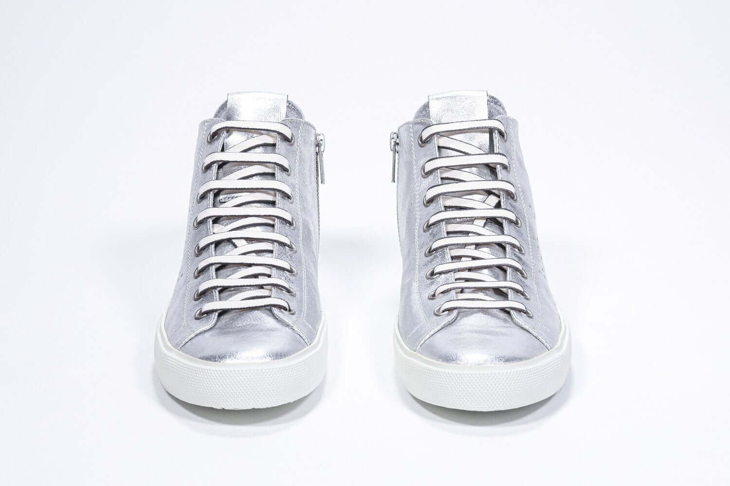 Vue de face du modèle mid top argenté sneaker avec une tige en cuir avec un logo perforé, une fermeture éclair interne et une semelle blanche.