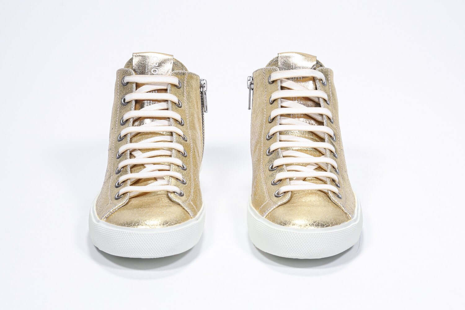 Vue de face du modèle mid top gold sneaker avec une tige en cuir avec un logo perforé, une fermeture éclair interne et une semelle blanche.