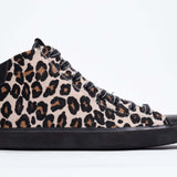 Side profile of mid top leopard print sneaker with full hair calf leather upper, internal zip and black sole.
