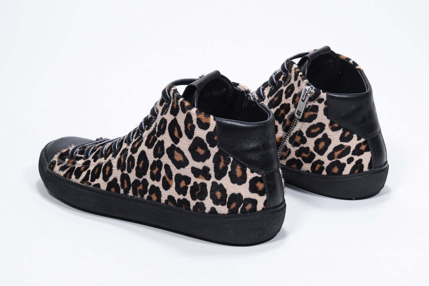 Three quarter back view of mid top leopard print sneaker with full hair calf leather upper, internal zip and black sole.