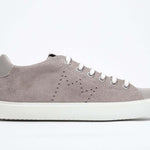 Profil latéral de la chaussure beige sneaker avec le logo perforé de la couronne sur la tige. Tige en daim et semelle en caoutchouc blanc.