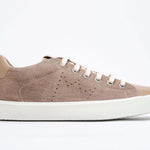 Profil latéral de la chaussure basse cuoio sneaker avec le logo perforé de la couronne sur la tige. Tige en daim et semelle en caoutchouc blanc.