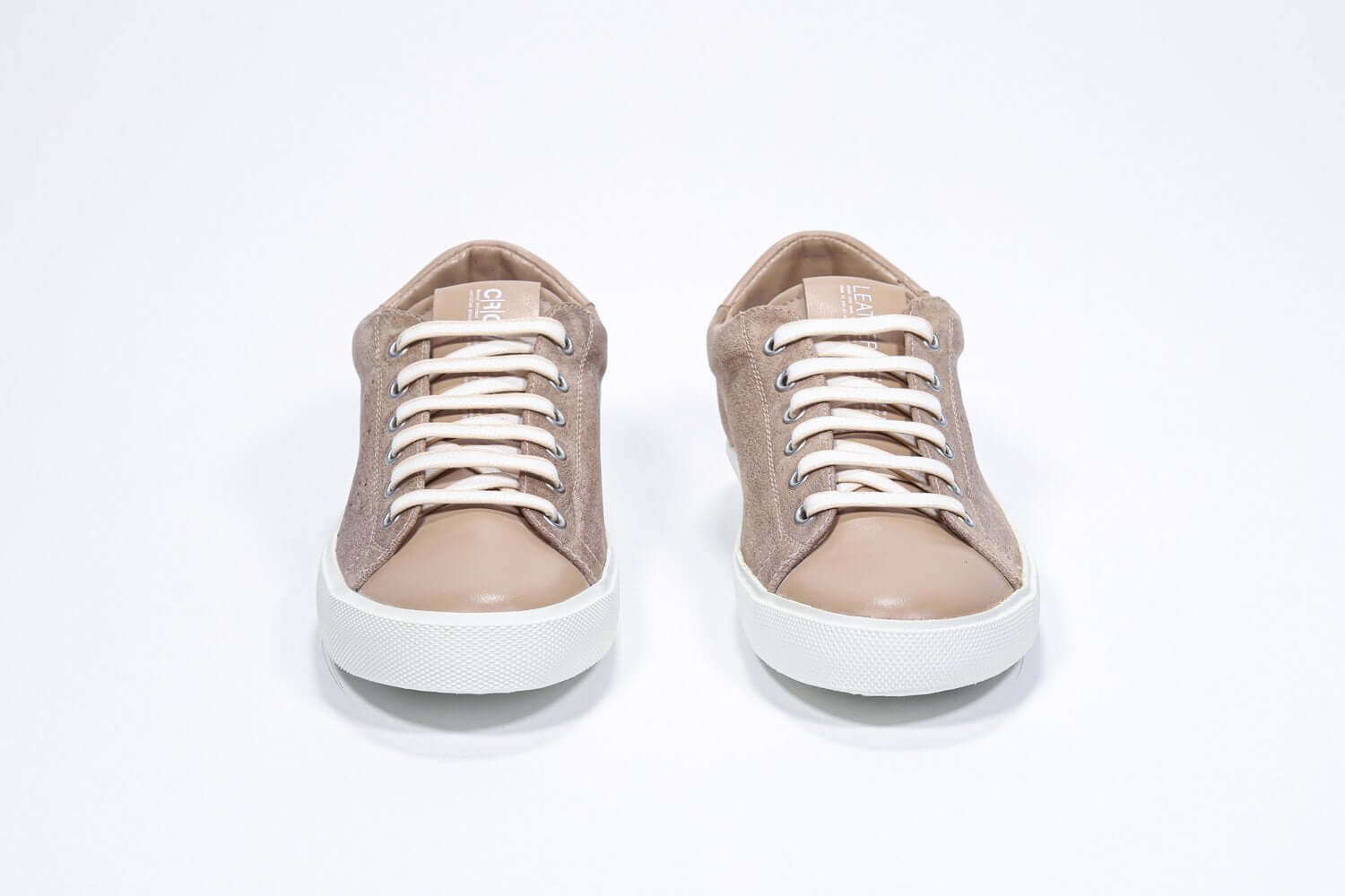 Vue avant de la chaussure basse cuoio sneaker avec le logo perforé de la couronne sur la tige. Tige en daim et semelle en caoutchouc blanc.