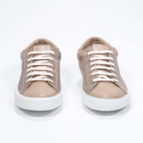 Vue avant de la chaussure basse cuoio sneaker avec le logo perforé de la couronne sur la tige. Tige en daim et semelle en caoutchouc blanc.