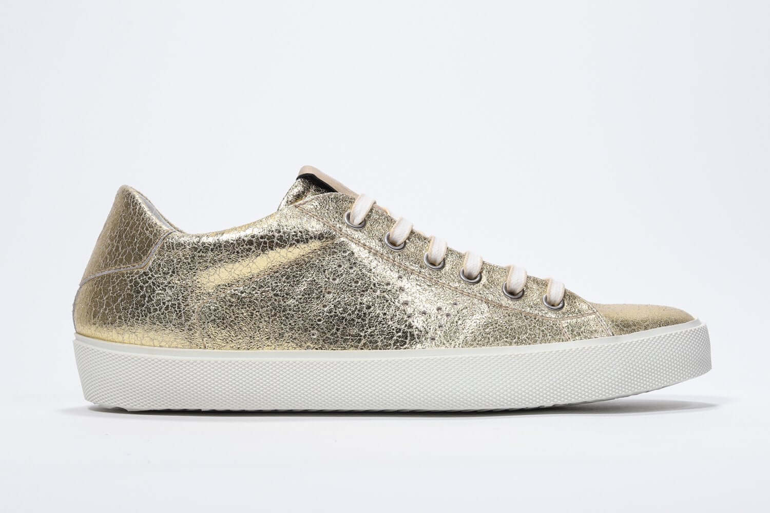 Seitliches Profil des goldenen Low Top sneaker mit perforiertem Kronenlogo auf dem Obermaterial. Obermaterial aus Metallic-Leder und weiße Gummisohle.