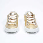 Vorderansicht des goldenen Low Top sneaker mit perforiertem Kronenlogo auf dem Obermaterial. Obermaterial aus Metallic-Leder und weiße Gummisohle.