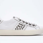 Profil latéral de la chaussure blanche sneaker. Tige en cuir avec clous et semelle en caoutchouc vintage.