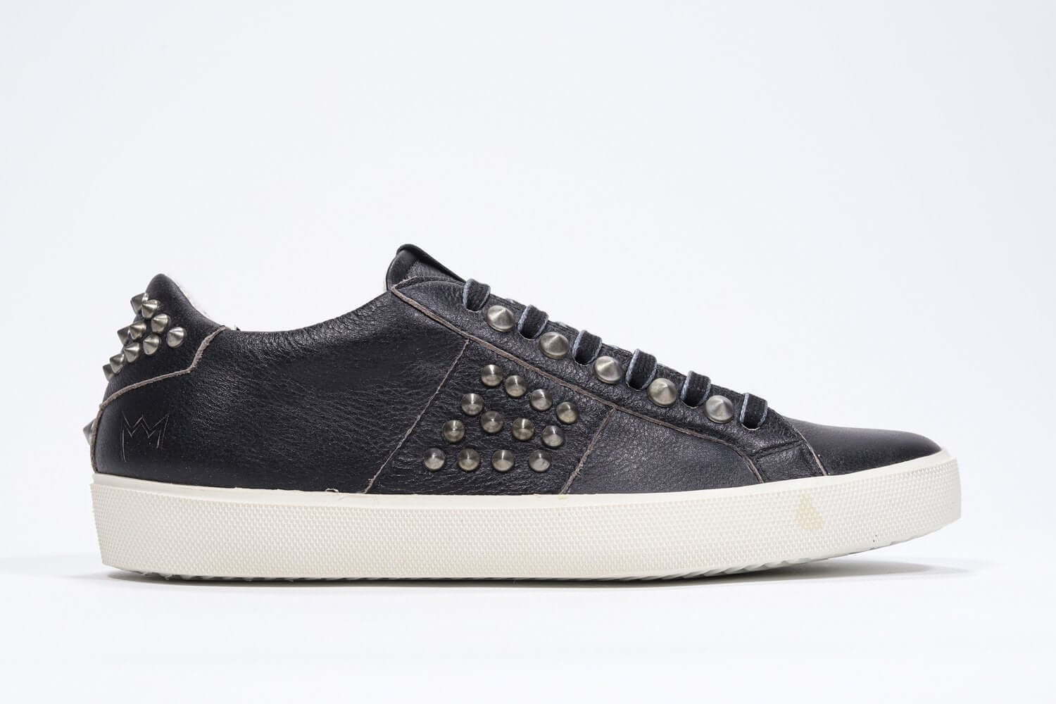 Profilo laterale di BASSE nero sneaker. Tomaia in pelle con borchie e suola in gomma anticata.