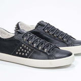 Tre quarti di BASSE nero sneaker. Tomaia in pelle con borchie e suola in gomma anticata.