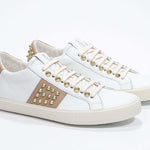 Dreiviertelansicht der Vorderseite von Low Top weiß und cuoio sneaker. Obermaterial aus Vollleder mit Nieten und Vintage-Gummisohle.